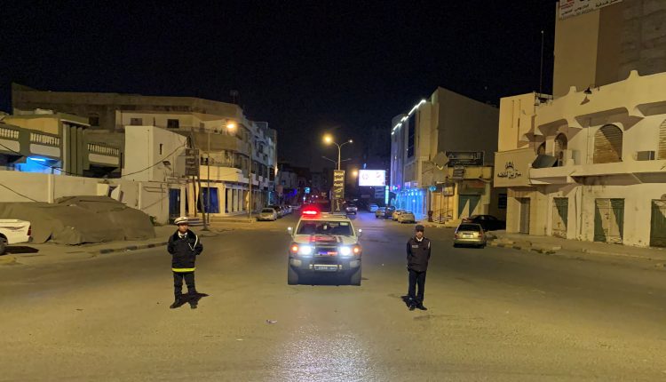 Police officers stand in the middle of the road during a curfew in Misrata